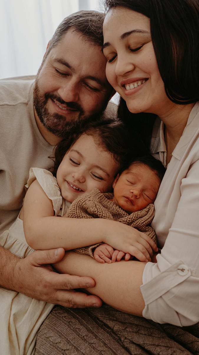 Família abraçada com seus dois filhos, fotografada pela LiiT